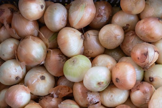 A vibrant pile of fresh onions displayed in a market basket. Perfect for culinary themes.