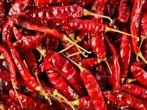 High-resolution image of dried red chili peppers in a pile, showcasing texture and detail.