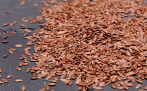 High-resolution close-up of nutritious flaxseeds scattered on a dark background, perfect for health and diet concepts.